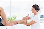 Physiotherapist doing leg massage in medical office