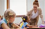 Teacher helping a little girl during class at the elementary school