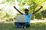 Cute little boy with laptop on a sunny day