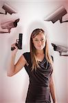Femme fatale pointing gun up against cctv camera