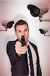 Serious businessman pointing a gun against cctv camera