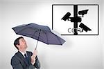 Businessman sheltering under black umbrella against cctv