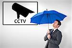 Businessman sheltering under blue umbrella against cctv