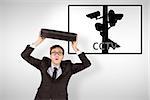 Young geeky businessman holding briefcase against cctv