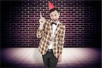 Geeky hipster in party hat  against purple vignette