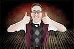 Smiling geeky hipster looking at camera showing thumbs up against grey vignette