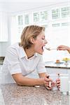 Mother and daughter having breakfast at home in kitchen