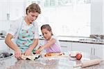 Mother and daughter baking together at home in kitchen
