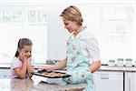 Mother and daughter with hot fresh cookies at home in kitchen