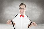 Geeky hipster pulling his suspenders against grey room