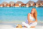 Rear view of young lady relaxing in the pool and enjoying view of beautiful seascape, refreshing in cool transparent water, summer holidays concept