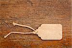 blank paper price tag with a twine against a rustic wood
