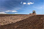 Agricultural Lanscape - Tractor working on the field - spring sunny day