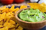 Guacamole in Wooden Bowl with Tortilla Chips Close Up