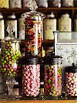 Traditional sweets displayed in tall glass jars on the shelves of a sweet shop.