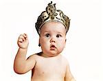 1960s BABY WEARING CROWN TIARA RAISED ARM LOOKING AT CAMERA