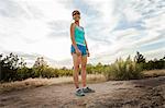 Portrait of mid adult woman standing on dirt track