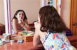 Girl applying lipstick in bedroom mirror