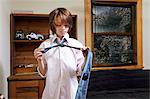 Boy practicing tying large tie in bedroom