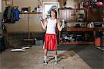 Slim boy struggling to lift hand weights in garage