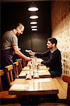 Man paying his bill in restaurant, using credit card