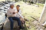 Husband and wife toasting by stream, Hahn Park, Los Angeles, California, USA