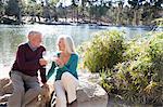 Husband and wife toasting by lake, Hahn Park, Los Angeles, California, USA