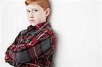 Boy crossing arms leaning against wall