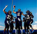 Teenage and young male american football team celebrating