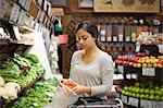 Young woman selecting red pepper at health food store