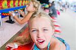 Portrait of girl pulling faces at fairground stall