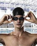 Male swimmer adjusting swimming goggles