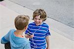 Two boys wearing earphones