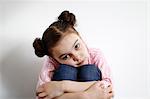 Portrait of a 8 years old girl, head on knees, and she is crossing her arms