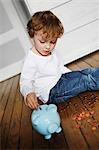 Boy putting coins in piggy bank