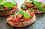 Italian tomato bruschetta with chopped vegetables, herbs and oil on grilled or toasted crusty ciabatta bread