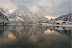 View over a Swiss Village by a lake in the Alps, covered in snow during winter.