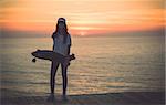 Beautiful and fashion young woman posing with a skateboard