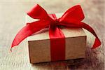 Gift with a red bow on a wooden background
