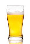 glass of fresh beer with drops on white background, with reflection on table