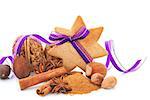 Gingerbread star cookie with hazelnut, cinnamon and purple ribbon. Natural brown christmas still life. Aromatic culinary spices and various nuts.