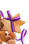 Gingerbread star cookie with hazelnut, cinnamon and purple ribbon. Natural brown christmas still life.