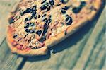 Rustic pizza with salami, mozzarella, corn and olives