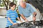 Father teaching his son basic auto maintenance.