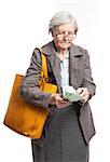 Senior woman counting money while standing over white background
