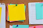 Blank, colourful notes pinned into brown corkboard