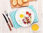 Healthy breakfast with fried egg, toasts and salad on white wooden table