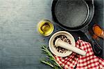 food background with cast iron skillet, herbs and spices selection