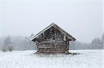 wooden old hut at snowfall in Bavarian Alps, Germany