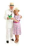 Senior couple dressed up for the Kentucky Derby, drinking mint juleps.  Full body isolated on white.